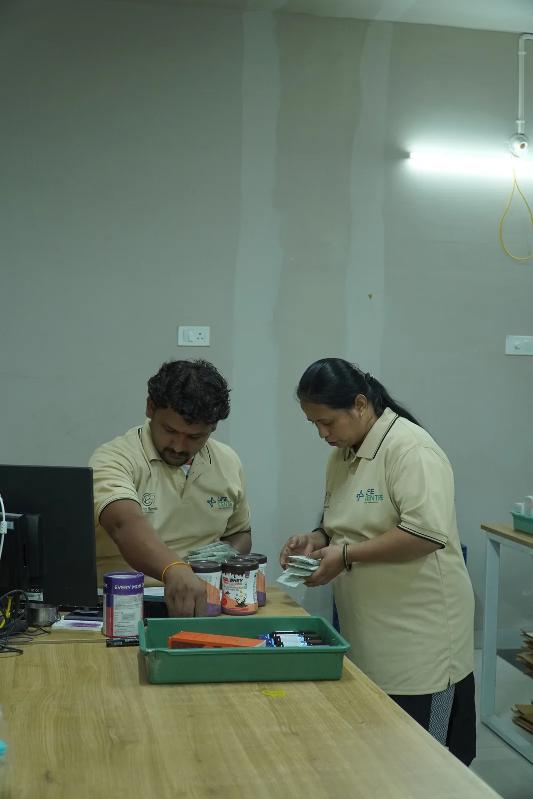 Team members preparing and packing orders at the Life Centre counter
